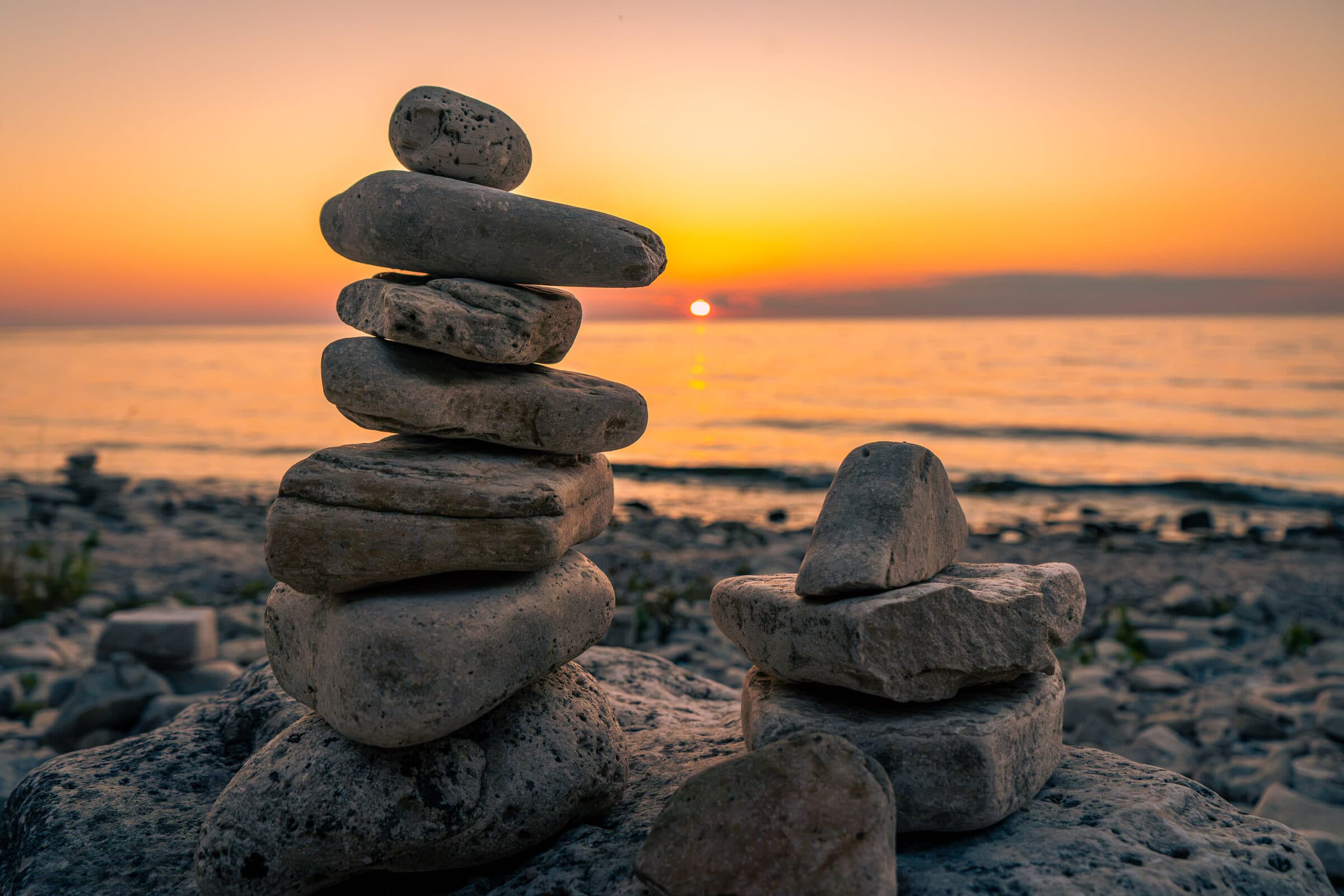 Balanced stones by the lakeshore at dusk